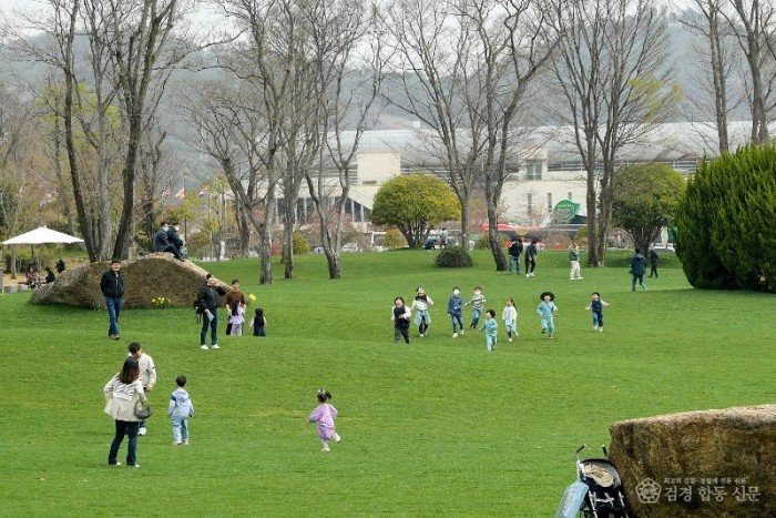 푸른 잔디가 펼쳐진 키즈가든에서 아이들이 뛰어 놀고있다.jpg