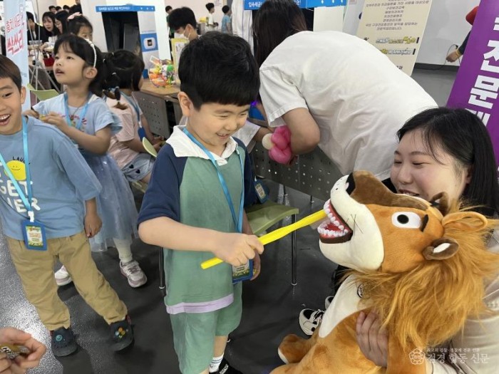 영주-3-2 구강교육에 참가한 아이가 사자인형 이를 닦아주며 즐거워하고 있다.jpg